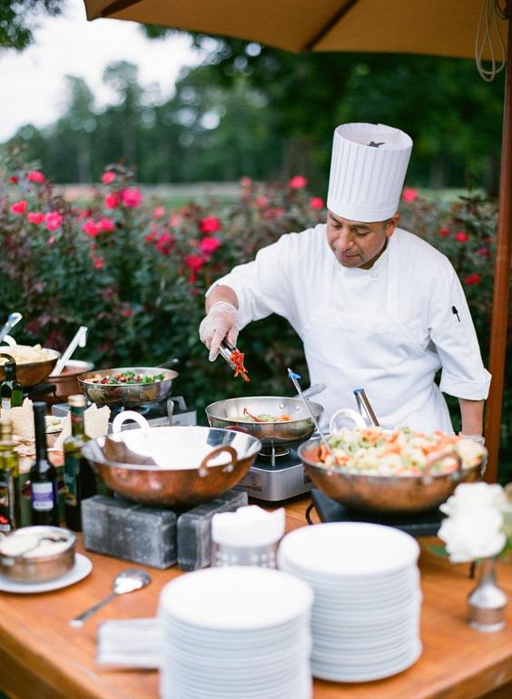 Live cooking station by a professional chef showcasing indoor vs outdoor wedding catering in Kerala, highlighting setup differences, ambience, and guest experience.